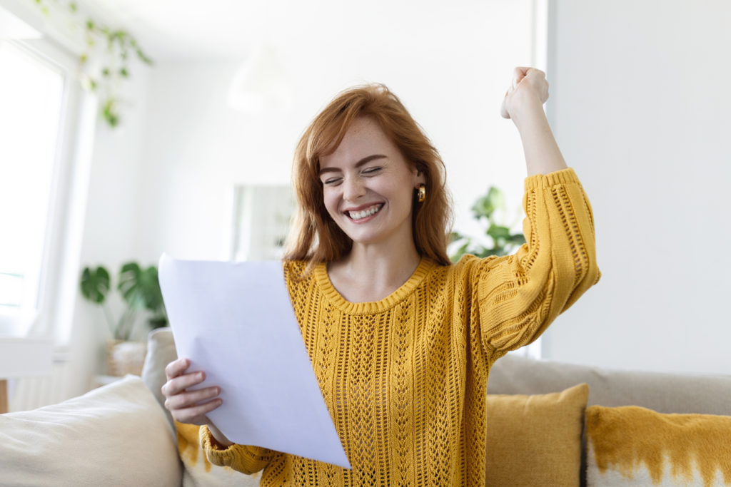 Excited young woman hold paper letter